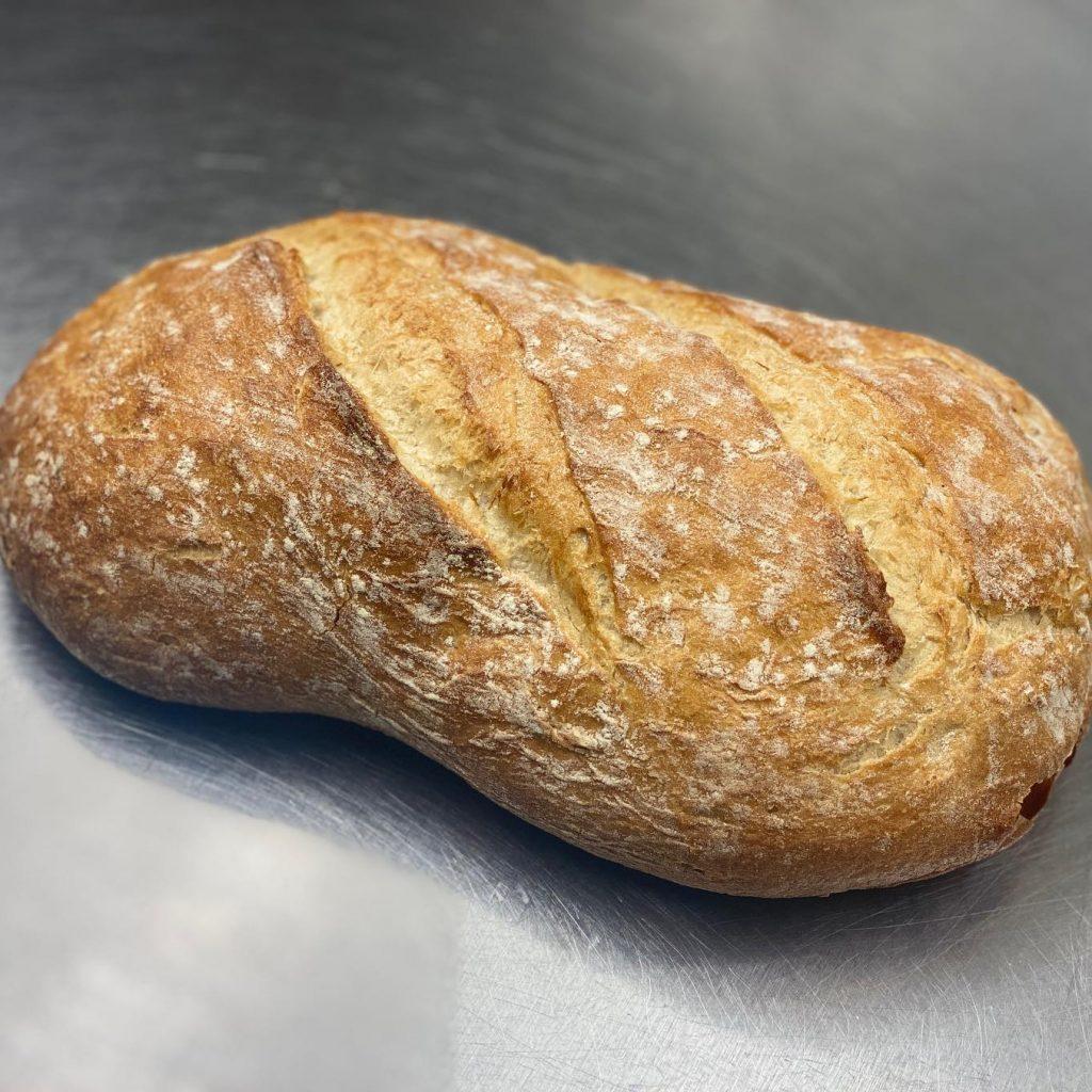 A freshly baked uncut farmers white loaf.